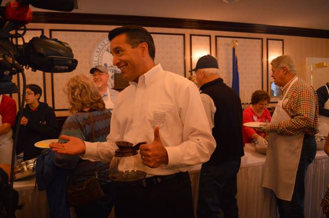 Gov. Brian Sandoval talks to a TV reporter at the annual Nevada Day pancake breakfast at the Governor's Mansion in Carson City on Saturday, Oct. 26, 2013.